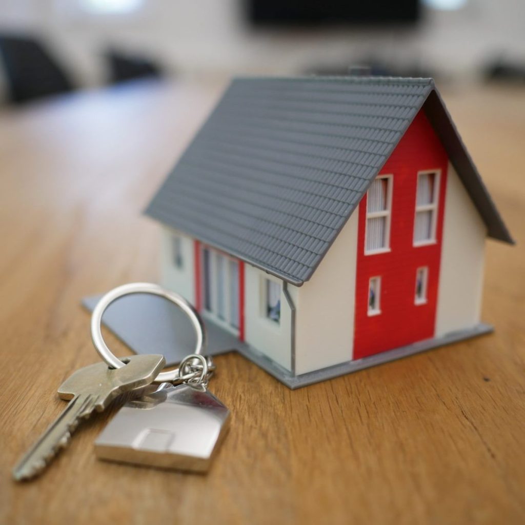 white and red wooden house miniature on brown table